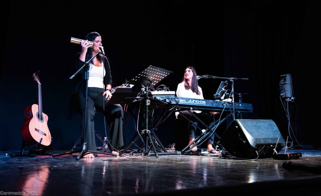 Due musiciste sul palco: una con il microfono, una alla tastiera