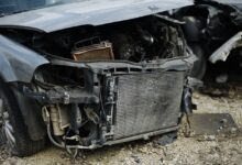Carcassa di un veicolo fuori uso con parti di ricambio a terra (immagine di repertorio)