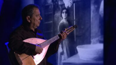 Mauro Palmas suona il liuto cantabile davanti alle immagini del film Cainà