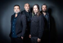 I quattro musicisti dei Calibro 35 in posa su sfondo scuro
