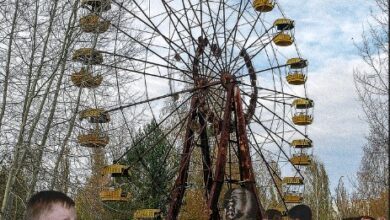 Bambini davanti alla ruota panoramica abbandonata di Pripyat, con una cicogna in volo