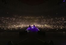 Fabrizio Moro sul palco del Palazzo dello Sport di Roma davanti al pubblico con le luci dei telefoni accese
