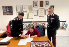 Una delle donne truffate firma il verbale di restituzione dei gioielli davanti ai Carabinieri