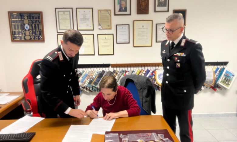 Una delle donne truffate firma il verbale di restituzione dei gioielli davanti ai Carabinieri