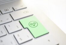 Tastiera di un computer portatile con un tasto verde con faccina sorridente