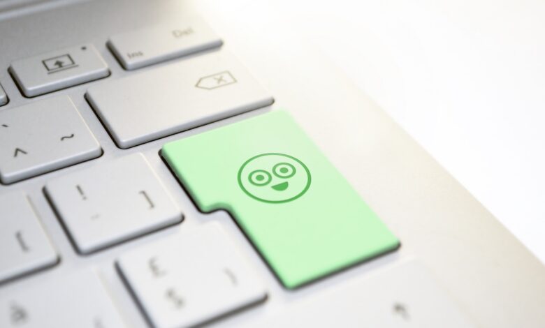 Tastiera di un computer portatile con un tasto verde con faccina sorridente
