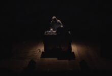 Un musicista elettronico suona al buio, illuminato da un taglio di luce: LÀMINE, format di Coru Aresti