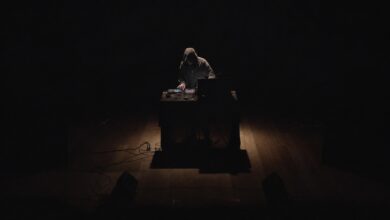 Un musicista elettronico suona al buio, illuminato da un taglio di luce: LÀMINE, format di Coru Aresti