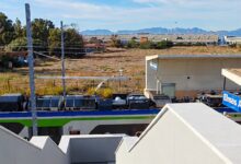 Il nuovo ingresso della stazione ferroviaria di Elmas Aeroporto con un treno in sosta al binario