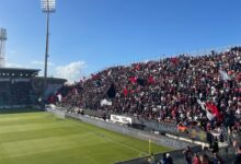 Tifosi del Cagliari con bandiere rossoblù sugli spalti della Unipol Domus