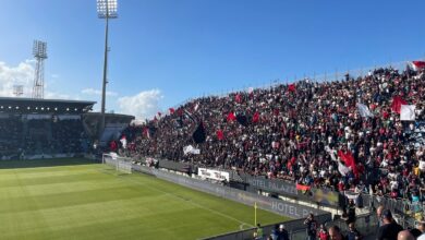 Tifosi del Cagliari con bandiere rossoblù sugli spalti della Unipol Domus