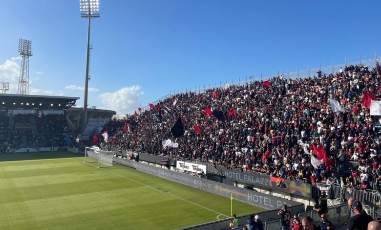 Tifosi del Cagliari con bandiere rossoblù sugli spalti della Unipol Domus